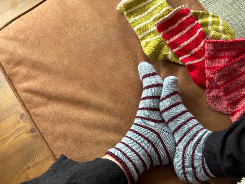Håndstrikkede plagg med garnnøster og pinner